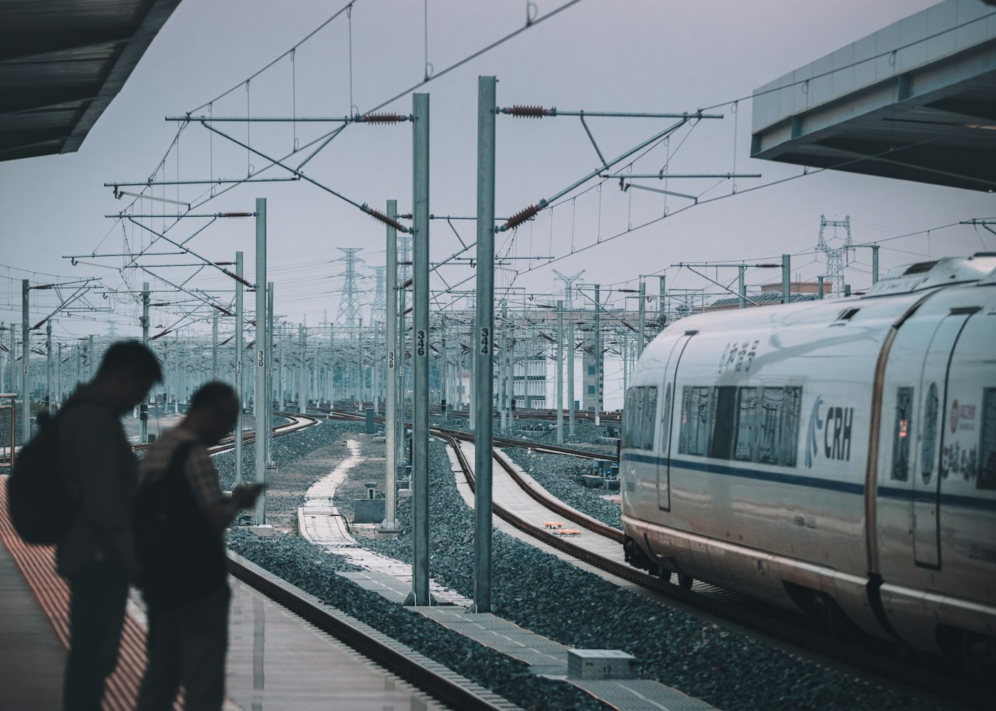 Zwei Pendler warten auf dem Bahnsteig auf ihren Zug